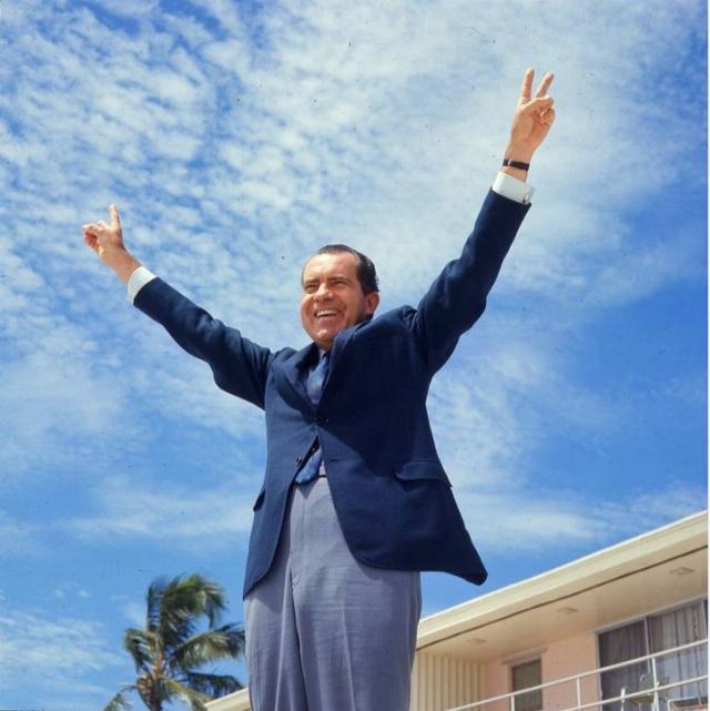 Nixon flashing victory sign.