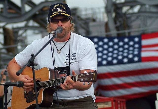 <p><em>Image: Toby Keith. Credit: Journalist 2nd class Brandan W. Schulze, U.S. Navy, via <a href="https://picryl.com/media/two-time-academy-of-country-music-entertainer-of-the-year-toby-keith-performs-a973f4">Picryl</a>.</em></p>